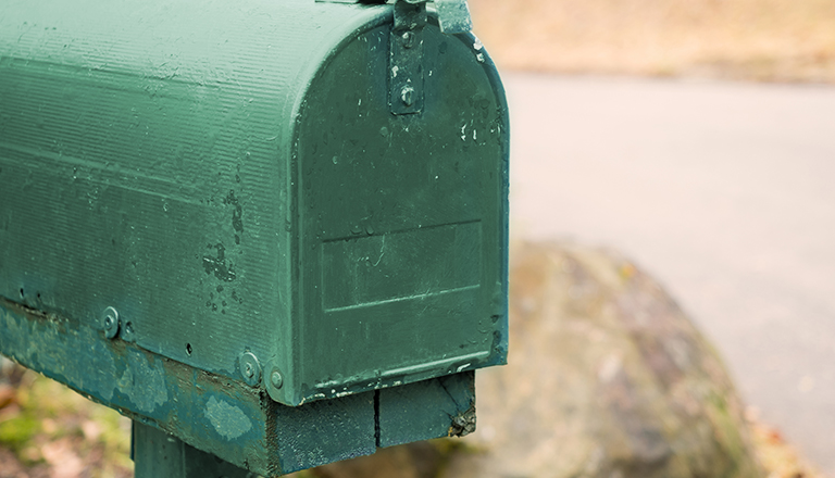 A man in a black shirt holds a green recycling bin